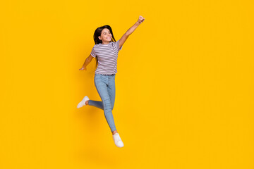 Wall Mural - Full size photo of young cheerful girl jump fly power look empty space isolated over yellow color background