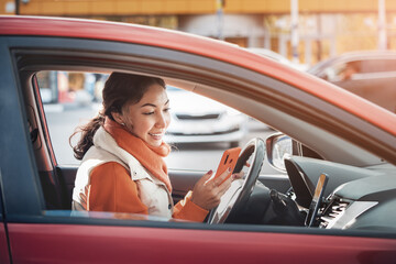 A female taxi or carsharing driver looks into her smartphone app to accept a call or navigate online maps