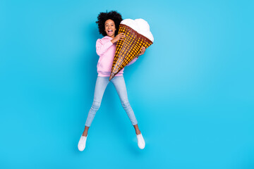 Poster - Full size photo of young girl have fun jump energetic holding big ice cream isolated over blue color background