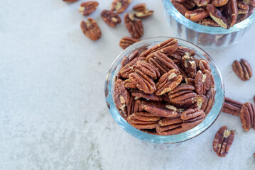 Poster - roasted pecan nut in glass bowl on white table background.