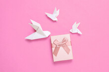 Origami Pigeons With Gift Box On Pink Background