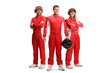 Racer and members of a racing team in red overall suits posing and looking at camera