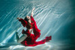 © Inna888stock - Attractive red-haired young woman swims beautifully underwater in a red dress
