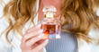 Woman with bottle of perfume. Perfume bottle woman spray aroma. Woman holding a perfumes bottle. Woman presents perfumes fragrance. Womans with perfum bottle. Beautiful girl using perfume