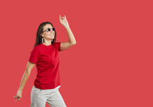Cheerful Positive Woman In Funny Glasses With Stars Isolated On Vivid Red Background. Young Casual Woman With Festival Accessories Having Fun Near Copy Space. Banner. Advertising. Isolated.
