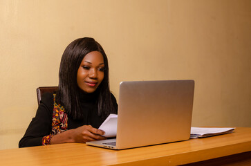 Wall Mural - beautiful lady in the office smiling as she goes through the file on her hand