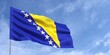 Flag of Bosnia and Herzegovina on flagpole on blue sky background. Bosnian flag fluttering in the wind against a sky with clouds. Place for text. 3d illustration.