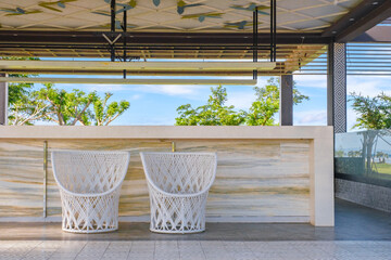 Beautiful outdoor kitchen with two round rattan chairs