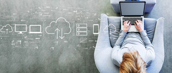 Wall Mural - Cloud computing with man using a laptop in a modern gray chair