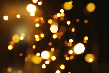 Wall Mural - Festive golden luminous background with lights bokeh. Abstract glowing bokeh lights