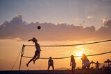 Fototapeta Na sufit - Friends playing volleyball on beach at sunset