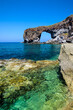 Natural volcanic arch formed from lava on the crystal clear tyrrhenian sea in Punta Perciato, Pollara, Salina. Rocky coastline, Aeolian Islands Archipelago, Sicily, Italy.
