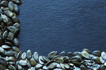 Wall Mural - Photography of pumpkin seed s on slate background for menus, labels or signs