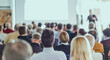© kasto - Speaker giving a talk in conference hall at business meeting event. Rear view of unrecognizable people in audience at the conference hall.