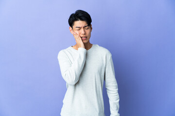 Wall Mural - Young Chinese man isolated on purple background with toothache