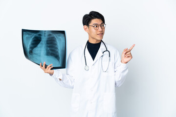 Wall Mural - Young Chinese doctor man holding radiography isolated on white background pointing up a great idea