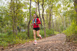 © EduLife Photos - Young fitness sportswoman trail runner running in the tropical forest park in the evening