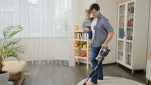 Young Single Father Doing Housework And Cleanup With His Little Baby Son