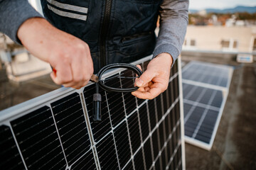 Wall Mural - Worker installing new solar panels. Worker hold connect cable