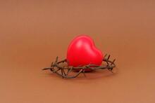 On The Brown Surface Is A Red Heart, Which Is Surrounded By Barbed Wire.
