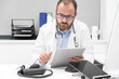 © herraez - Doctor using his tablet computer at work. High quality photo