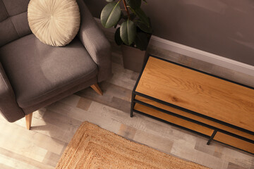 Poster - Wooden cabinet and comfortable armchair near grey wall in room, above view