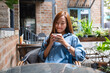 © Farknot Architect - Portrait image of a beautiful young asian woman holding and drinking hot coffee in the outdoors cafe