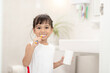 © FAMILY STOCK - Little cute baby girl cleaning her teeth with a toothbrush in the bathroom
