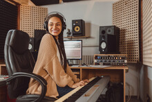 Attractive Stylish African American Female Musician Sound Engineer Playing Synthesizer While Working In Recording Studio