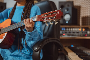 Wall Mural - Talented female guitarist keeps her fingers on the strings while playing the guitar