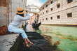 woman sitting at city quay at venice italy enjoying the view of canals with gondolas