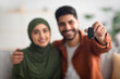 © Prostock-studio - Happy Middle Eastern Couple Showing Automobile Key To Camera Indoors