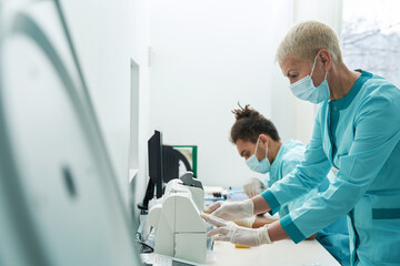 Wall Mural - Two collegues are working in clinic laboratory