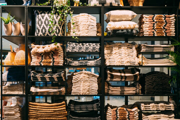 Wall Mural - View of assortment of decor for interior shop in store of shopping center. View of shelving with pillows, plaid, towels. View of home accessories for bathroom, bedroom in shop fashion retail store