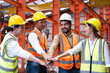 © BritCats Studio - Asian people group  worker with supervisor holding hand to cheer up and encourage before working at industrial factory site. Teamwork, labor brainstorm or group working concept.