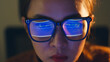 © Nattakorn - Close up of face of young Asian woman, developer programmer, software engineer, IT support, wearing glasses working hard at night overtime on computer to check coding in bugging system.
