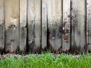 rain damage wooden fence wall garden green grass building discolored old wood