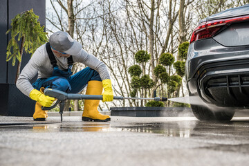 Canvas Print - Men Pressure Washing His Car in Front of a House