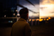 © Roman Osinski - Man silhouette unrecognizing person successful businessman enjoying the sunset near city skyscrapers with glass windows in the downtown reflection of sun lights. Concept of people looking in future.