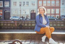 Blonde Girl Relaxing On The Waterfront In Nyhavn In Copenhagen