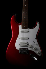 Red Electric Guitar On A Black Background. Fender