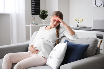 Poster - Young pregnant woman with headache sitting on sofa at home