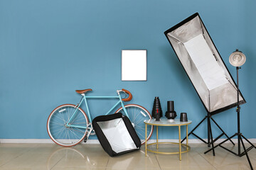 Wall Mural - Bicycle and table with different modern equipment near color wall in photo studio interior