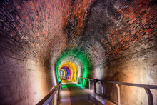 Dark Abandoned Railway  tunnel Illuminated By Colorful Light 