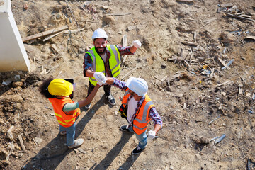 Wall Mural - Hand together top view. Successful teamwork unity. Mechanical Engineer and construction team at house project underconstruction site. Hands meeting together