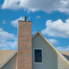 Square Whispy white clouds Two-tone bricks on a chimney post outside a house at Daybreak, U