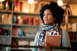 © Drazen - Portrait of black female adult student at university library looking away.