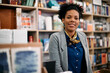 © Drazen - Portrait of happy black bookstore owner looking at camera.