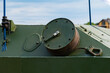 A drum with a wound cable on an armored personnel carrier in close-up.