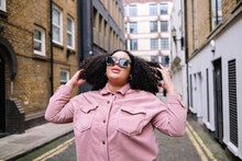 Young Woman Wearing Sunglasses Standing With Hand In Hair